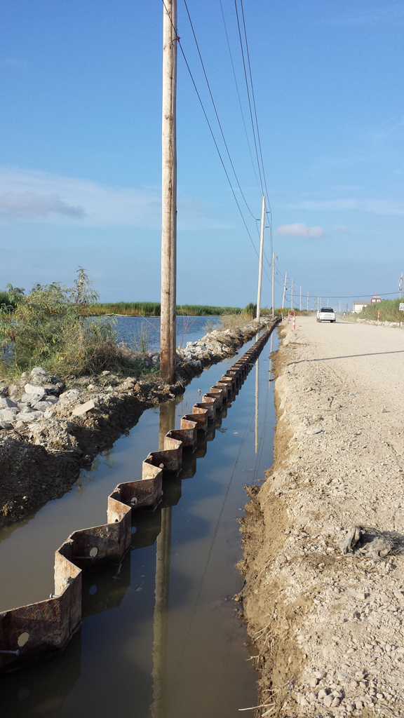 Dirt and gravel road surrounded by swamp and lake